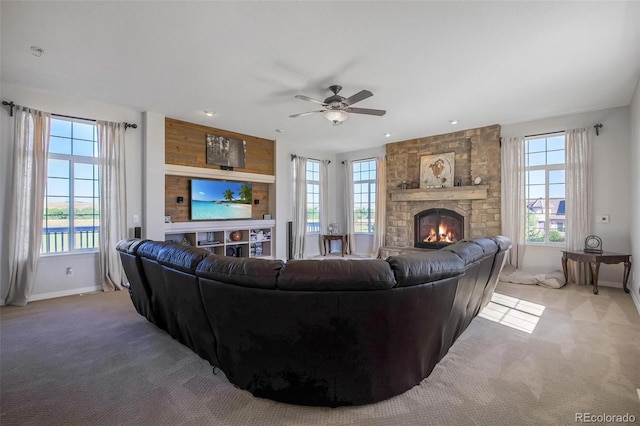 living room featuring ceiling fan, a fireplace, and carpet floors