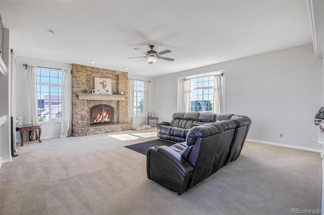 carpeted living room with ceiling fan and a fireplace