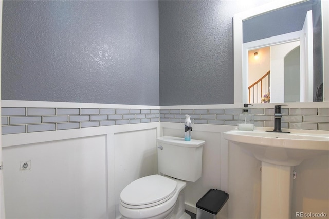 bathroom featuring toilet and tasteful backsplash