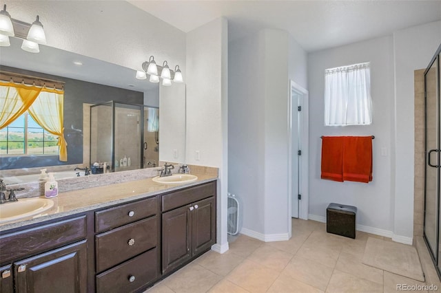 bathroom with a shower with door, vanity, and tile patterned floors