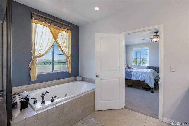 bathroom featuring a healthy amount of sunlight, ceiling fan, a relaxing tiled tub, and tile patterned flooring