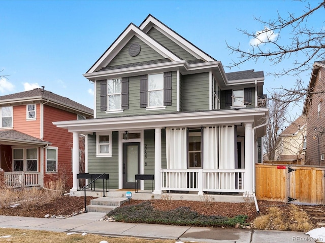 traditional-style home with fence and a porch