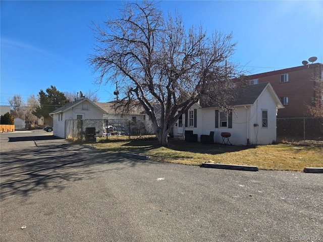 view of front of property featuring stucco siding, fence, and a front yard