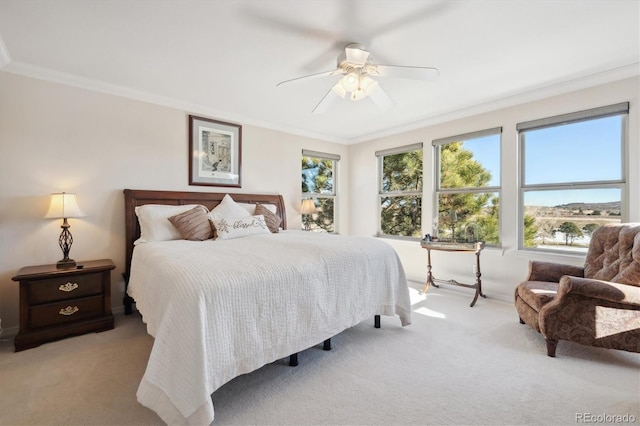 carpeted bedroom with crown molding and a ceiling fan