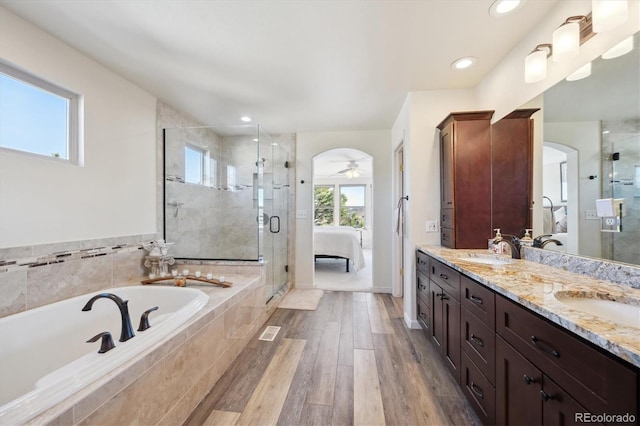 ensuite bathroom featuring a garden tub, a stall shower, a sink, connected bathroom, and double vanity