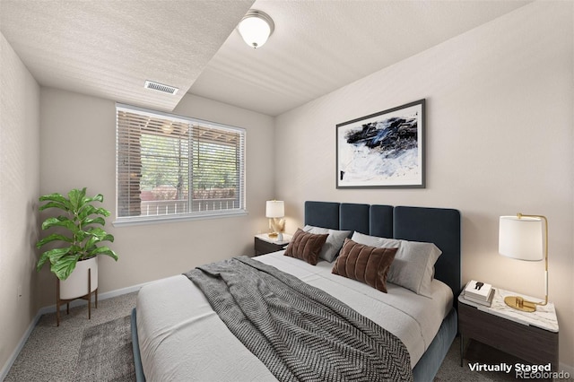 bedroom with carpet flooring, baseboards, and a textured ceiling
