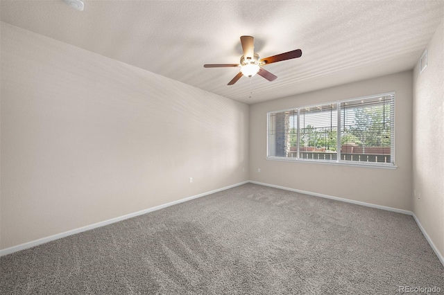 unfurnished room with ceiling fan, carpet, baseboards, and a textured ceiling