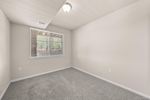 carpeted empty room featuring baseboards and a textured ceiling