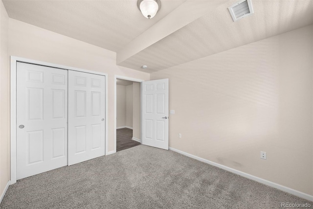 unfurnished bedroom featuring carpet, baseboards, and a closet