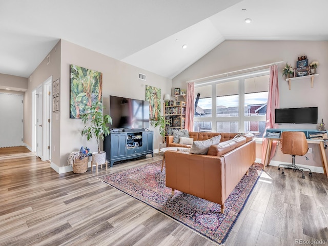 living room featuring lofted ceiling and light hardwood / wood-style flooring