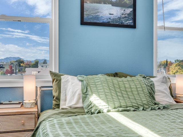 bedroom featuring a mountain view and multiple windows