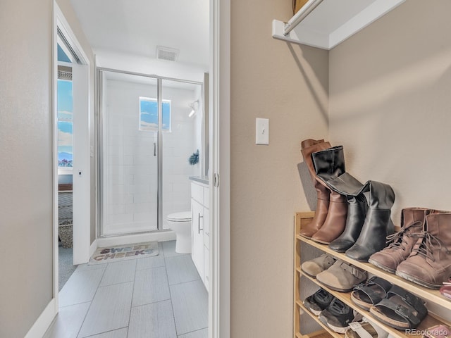 bathroom with a shower with door and toilet