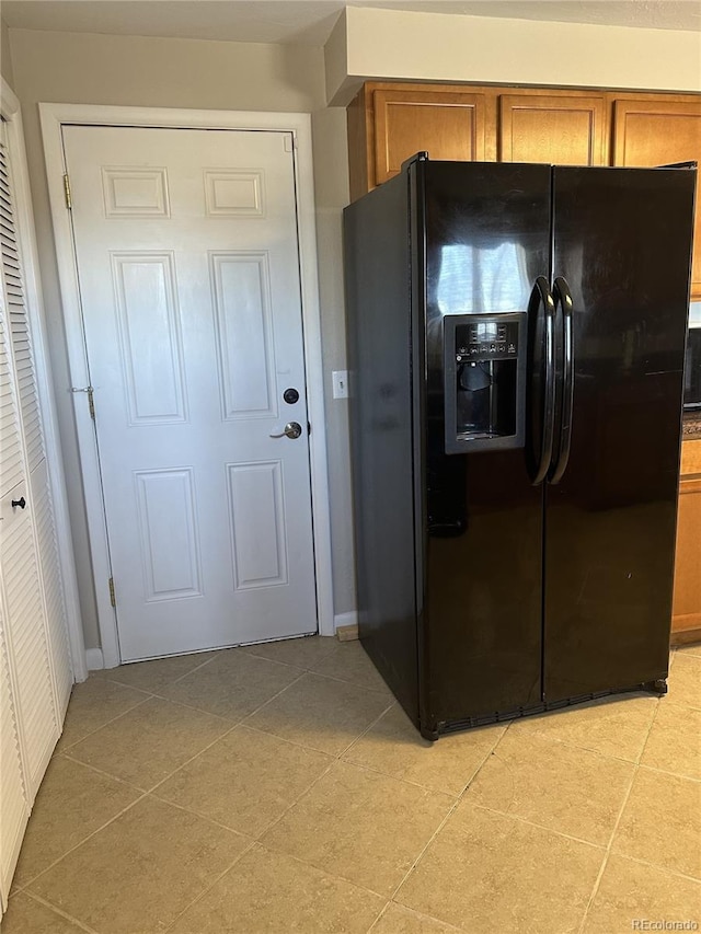 5879 Blue Spruce Ave, Alamosa, CO 81101 - kitchen with black refrigerator with ice dispenser, brown cabinetry, and light tile patterned flooring