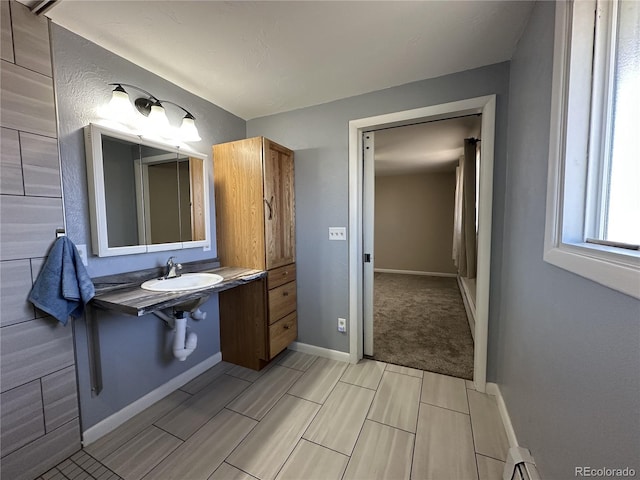 5879 Blue Spruce Ave, Alamosa, CO 81101 - bathroom featuring wood finish floors and a baseboard radiator