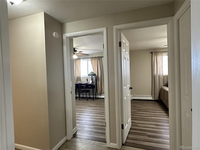 5879 Blue Spruce Ave, Alamosa, CO 81101 - hallway with a baseboard heating unit and wood finished floors