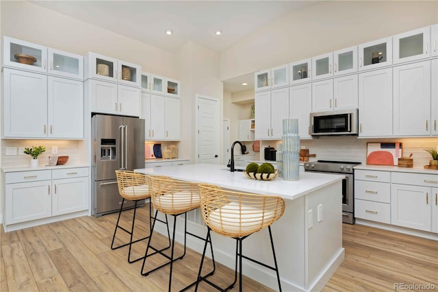 kitchen featuring white cabinetry, appliances with stainless steel finishes, and a center island with sink