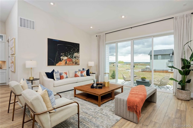 living room with vaulted ceiling and light hardwood / wood-style floors