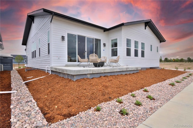 back house at dusk with a patio