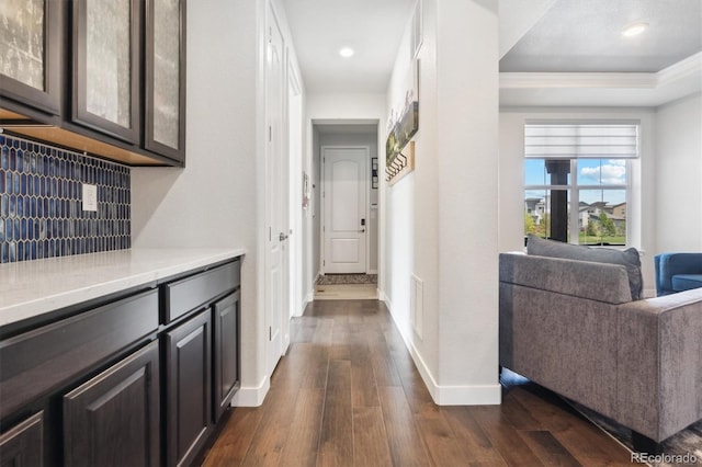 hall with dark hardwood / wood-style flooring and crown molding