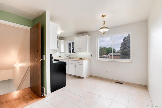 3961 S Uravan St, Aurora, CO 80013 - kitchen featuring white cabinets, light countertops, pendant lighting, black range with electric cooktop, and baseboards