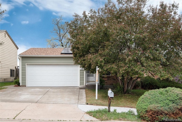 3961 S Uravan St, Aurora, CO 80013 - view of front facade featuring solar panels, driveway, a garage, and a shingled roof
