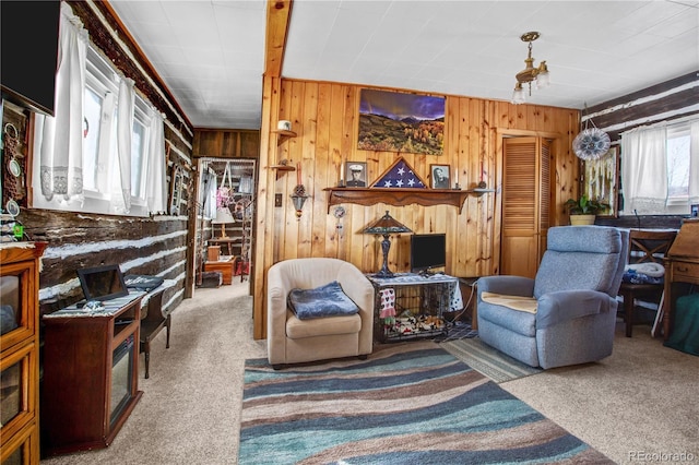 carpeted living room with wood walls