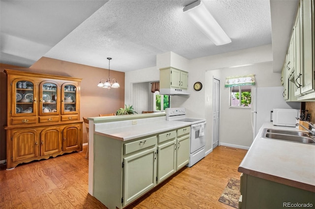 kitchen with white appliances, green cabinets, sink, light wood-type flooring, and a chandelier