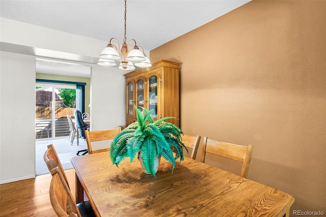 dining room with light hardwood / wood-style floors and an inviting chandelier