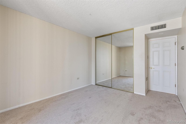 1020 15th St Unit 25D, Denver, CO 80202 - unfurnished bedroom with carpet flooring, a closet, a textured ceiling, and baseboards