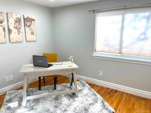 office space with wood-type flooring