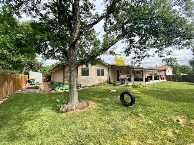 rear view of house featuring a patio and a lawn