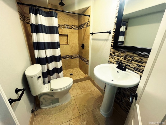 bathroom featuring toilet, decorative backsplash, and curtained shower