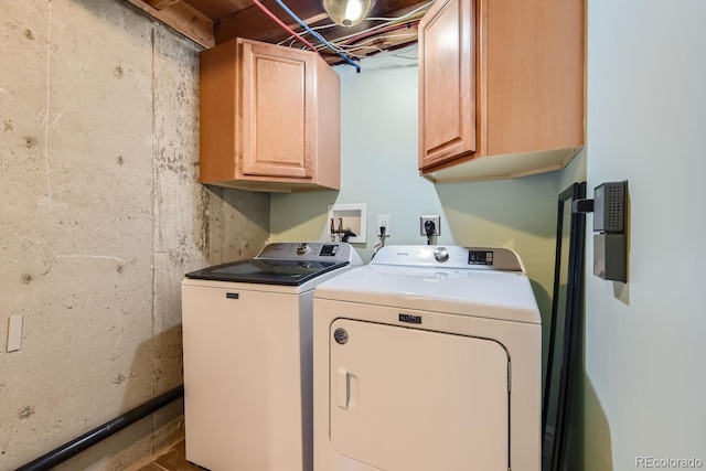 clothes washing area with cabinets and washing machine and dryer