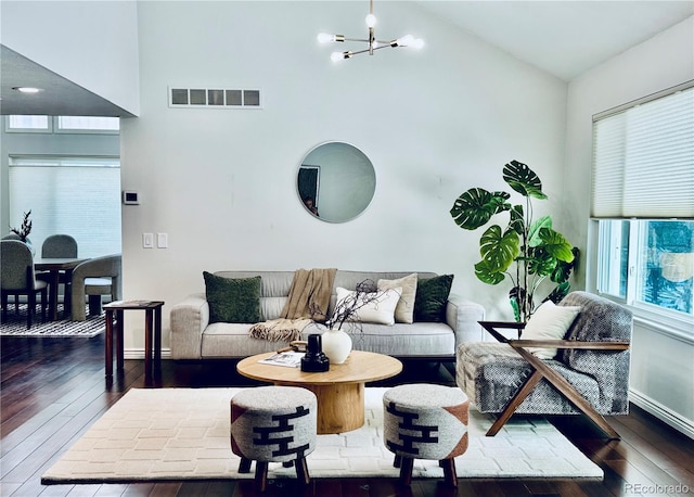 living area featuring dark wood-style floors, a chandelier, visible vents, and high vaulted ceiling