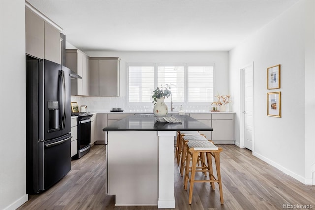15006 Cast Pebble Cir, Parker, CO 80134 - kitchen featuring fridge with ice dispenser, stainless steel range with gas cooktop, a breakfast bar, a center island, and gray cabinets