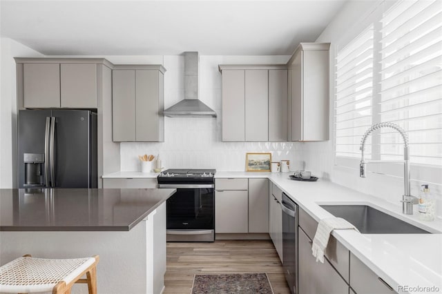 15006 Cast Pebble Cir, Parker, CO 80134 - kitchen with wall chimney exhaust hood, stainless steel appliances, gray cabinetry, and light wood-type flooring