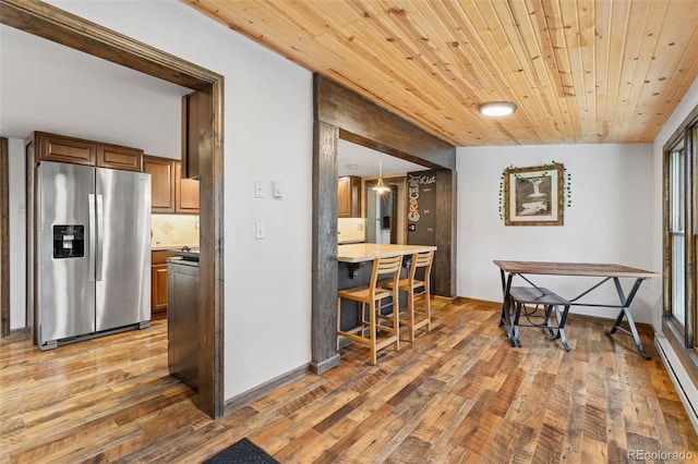 55 Two Moon Rd, Idaho Springs, CO 80452 - kitchen featuring stainless steel refrigerator with ice dispenser, brown cabinetry, light wood-style floors, wood ceiling, and light countertops