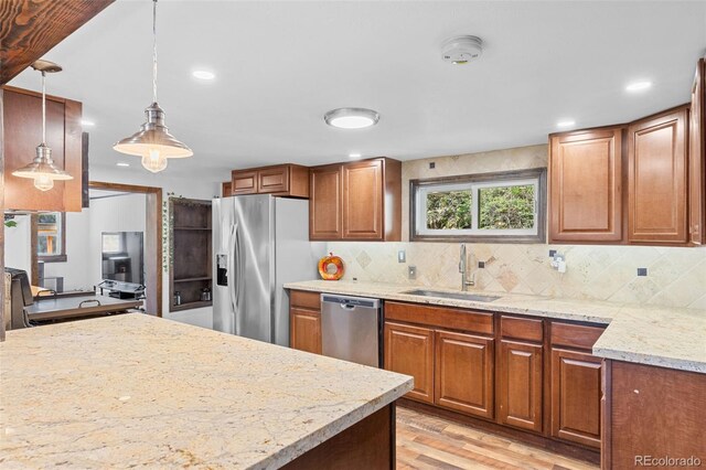 55 Two Moon Rd, Idaho Springs, CO 80452 - kitchen featuring appliances with stainless steel finishes, light wood-type flooring, decorative backsplash, brown cabinetry, and recessed lighting