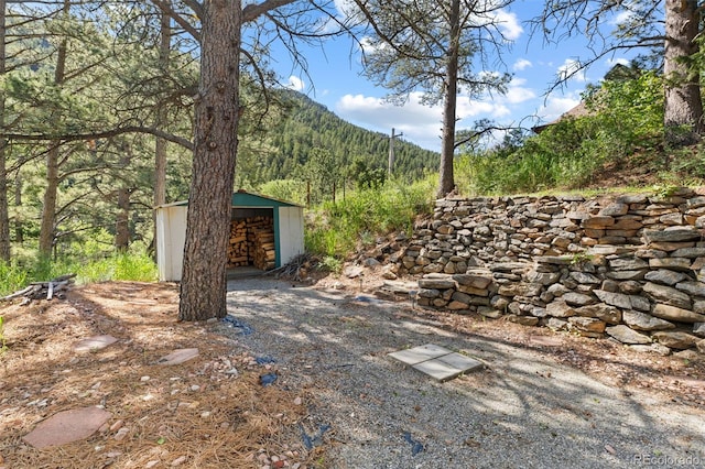 55 Two Moon Rd, Idaho Springs, CO 80452 - view of yard with an outbuilding, a view of trees, and a detached garage