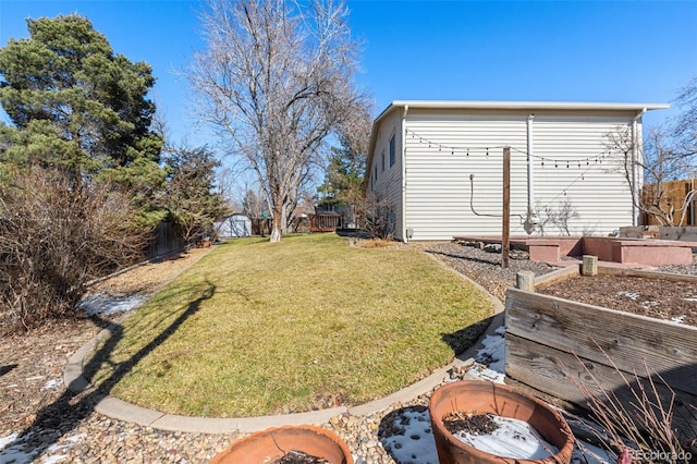 view of yard featuring a fenced backyard and a fire pit