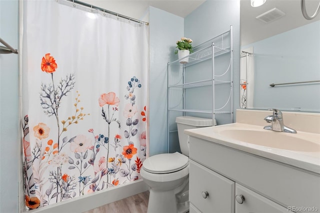 full bath with visible vents, toilet, a shower with curtain, wood finished floors, and vanity