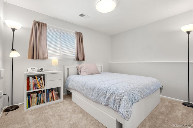 bedroom featuring visible vents, light carpet, and baseboards