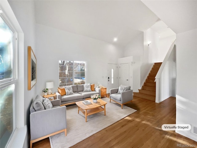 living room featuring hardwood / wood-style flooring and high vaulted ceiling