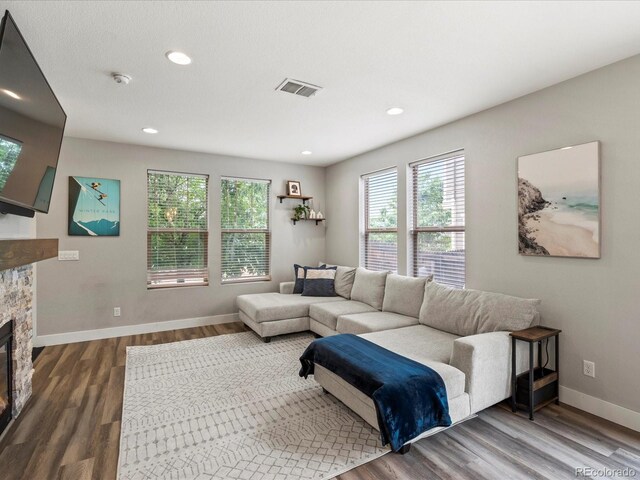 14823 W 70th Dr Unit A, Arvada, CO 80007 - living area with dark wood finished floors, a fireplace, baseboards, and recessed lighting
