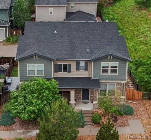 14823 W 70th Dr Unit A, Arvada, CO 80007 - view of front of house with a porch, stone siding, and roof with shingles