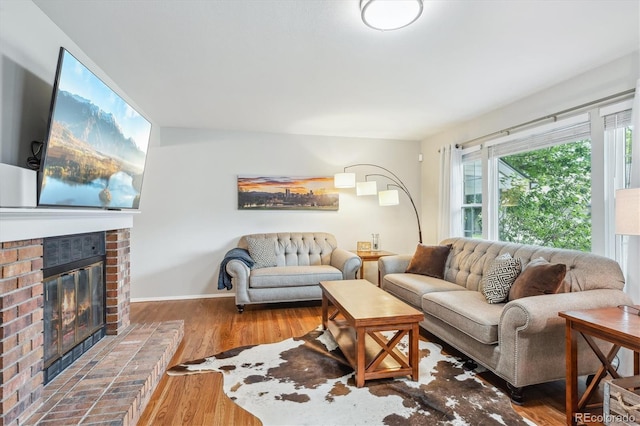 6880 E Appleton Cir, Centennial, CO 80112 - living area featuring a fireplace, wood finished floors, and baseboards