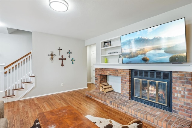 6880 E Appleton Cir, Centennial, CO 80112 - living area featuring a brick fireplace, wood finished floors, stairs, and baseboards