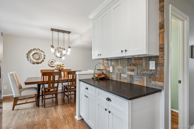 6880 E Appleton Cir, Centennial, CO 80112 - kitchen with decorative backsplash, dark countertops, white cabinetry, and light wood-type flooring