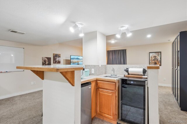 6880 E Appleton Cir, Centennial, CO 80112 - kitchen with a sink, light carpet, wine cooler, light countertops, and a peninsula