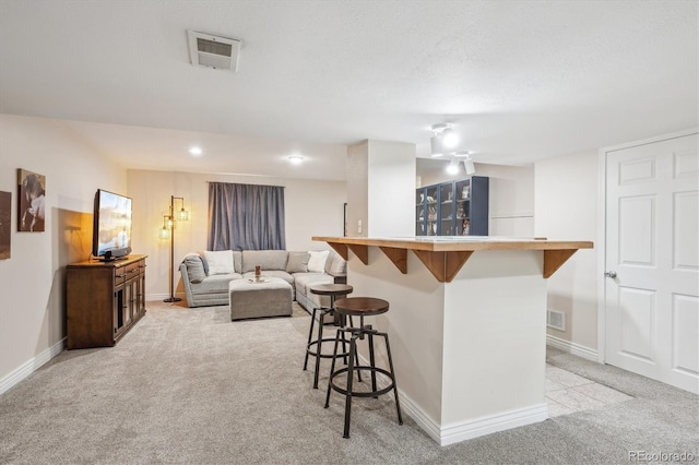 6880 E Appleton Cir, Centennial, CO 80112 - kitchen featuring light carpet, a kitchen bar, baseboards, and open floor plan